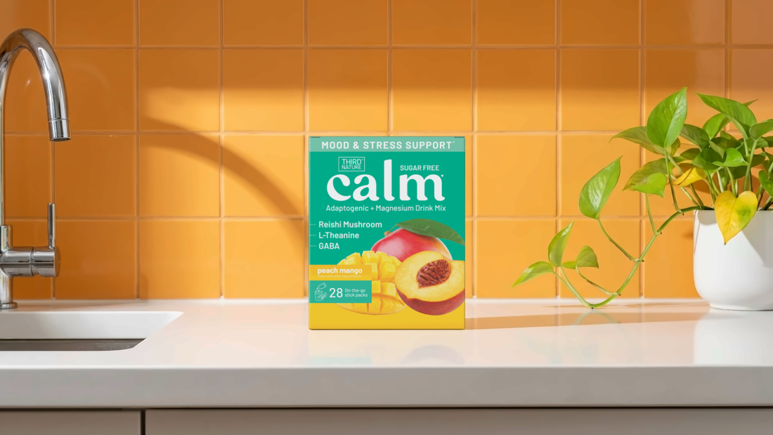 A 28-count box of Third Nature peach mango drink mix on a white kitchen counter in front of orange tile, with a tap and a pothos plant